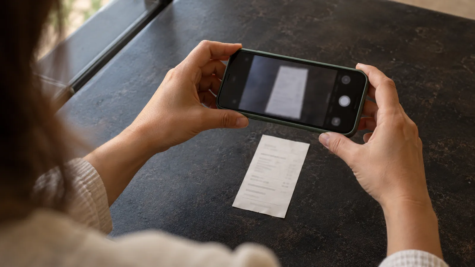 Un documento se escanea con el celular sobre una mesa plana. Ilustración creada con IA.